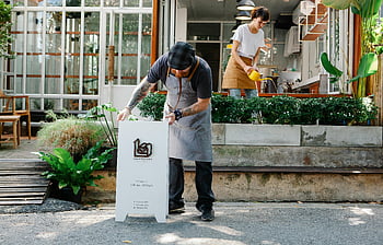 カフェの従業員、 屋外スペース、 植物、 看板、 昼間の営業、 カフェの準備、 通り、 同僚、 ビジネス準備、 カフェオープン、 植物の手入れ