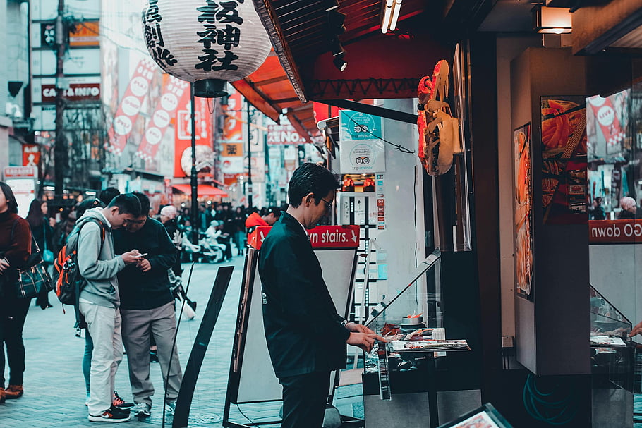 street market, paper lanterns, people shopping, Japan, bustling market, man in front, establishment, city street, traditional market, street scene, Japanese market