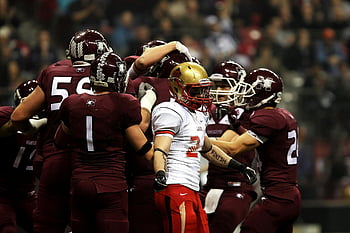 football players, celebrating play, college game, action shot, field celebration, team huddle, sports event, athletic competition, game day, team spirit, football uniforms
