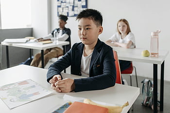 机に座っている男の子、 若い学生、 授業に集中する、 教室の設定、 学ぶ準備ができました、 スクールデスク、 バックグラウンドの仲間、 教育環境、 学生の関与、 学習環境、 教室でのアクティビティ