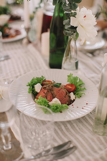 uvařené maso, zelenina, bílá deska, elegantní stolničení, gurmánské jídlo, salát, květinová výzdoba, uspořádání stolu, dobré jídlo, prezentace potravin, jídelní stůl