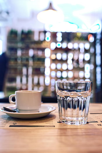 Kaffeetasse, Wasserglas, Holztisch, gemütliches Café, unscharfer Hintergrund, Café-Szene, Kaffee und Wasser, Kaffeetisch, Café, Cafe Interieur, Kaffeepause