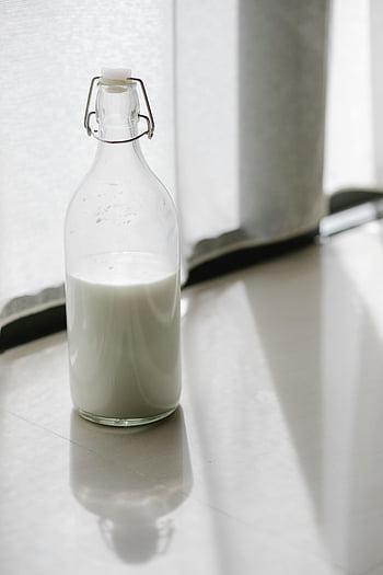 glass bottle, milk, sunlit floor, indoors, fresh milk, glass container, milk bottle, indoor lighting, table, white milk, glassware