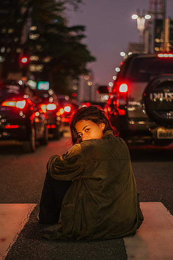 道路に座っている女性、 夜間、 横断歩道、 都市交通、 ピンぼけライト、 若い女性、 都会の風景、 夜間の写真、 ストリート写真、 街の明かり、 夜の街並み