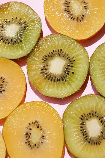 sliced kiwi, juicy kiwi, pink background, fresh kiwi, gold fruit slices, vibrant colors, healthy appeal, kiwi slices, fruit photography, kiwi fruit, healthy food