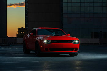 red car, Dodge Challenger, parked outdoors, urban area, twilight, red Dodge, car near building, striking red, outdoor parking, urban twilight, red vehicle