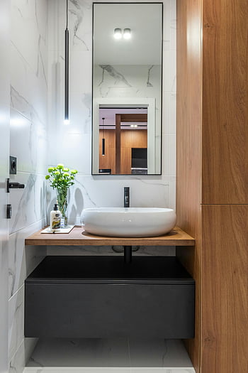 contemporary bathroom, marble sink, wooden accents, modern bathroom, stylish decor, elegant bathroom, marble walls, black drawer, wall-mounted sink, large mirror, minimalist design