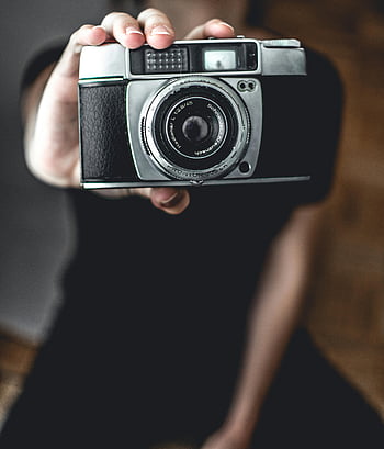 persona che tiene la fotocamera, macchina fotografica d'epoca, foto ravvicinata, dettagli intricati, design classico, lenti della macchina fotografica, macchina fotografica retrò, attrezzatura fotografica, telecamera che tiene la mano, primo piano della telecamera, fotografia d'epoca