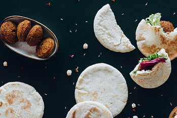 falafel, Pita brood, gesneden brood, zwarte tafel, donkere achtergrond, culinaire liefhebbers, heerlijke falafel, stijlvolle presentatie, Midden-Oosten eten, vegetarisch eten, gezond eten