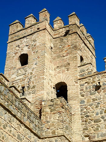 Stone Tower, Medieval Castle, Toledo Spain, historic architecture, clear blue sky, stone structure, medieval design, castle tower, historic building, European castle, ancient architecture