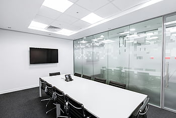 Konferenzraum, minimalistisches Design, Glaswände, langer Tisch, Bürostühle, Rollstühle, eleganter Innenraum, modernes Büro, weißer Tisch, professioneller Raum