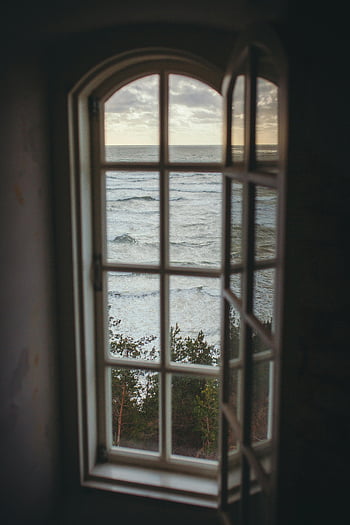 window overlooking ocean, serene ocean view, rustic window frame, peaceful escape, ocean through window, coastal view, ocean waves, tranquil scenery, seaside window, natural landscape, ocean panorama