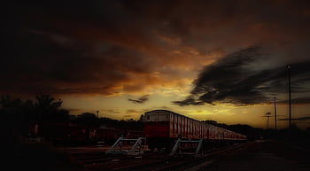 sunset, train, red and white train, vibrant sunset sky, dramatic clouds, serene silhouette, evening train, railway, outdoor photography, dusk, railway landscape