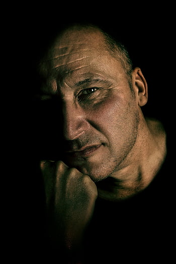 Daniel Craig, moody portrait, dramatic lighting, contemplative man, shadowy lighting, adult man, dark background, intense gaze, cinematic style, high contrast, studio shot