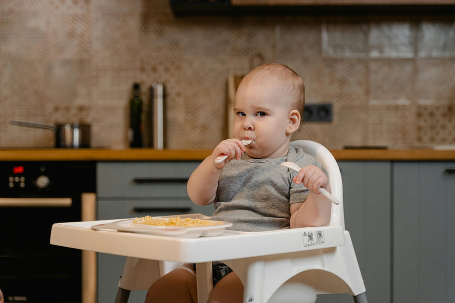 baby, gray shirt, high chair, eating food, cute baby, enjoying meal, innocence, joy, indoors, meal time, highchair
