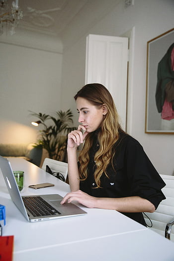 nő használ laptop, fókuszált munka, elegáns otthoni iroda, A laptopnál dolgozik, otthoni irodahely, nő dolgozik, laptop használat, otthoni munkavégzés, koncentrált nő, stílusos iroda, munkakörnyezet