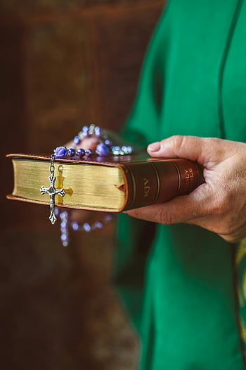 personne tenant la bible, chapelet sur la Bible, foi et spiritualité, symboles religieux, croix et chapelet, livre sacré, pratique spirituelle, dévotion religieuse, chapelet de prière, la foi chrétienne, imagerie spirituelle