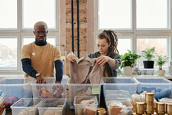 volontari, donazioni di abbigliamento, donazioni di cibo, interno, luce del giorno, Donna con dreadlocks, uomo in maglietta gialla, Sortendo i vestiti, carità, organizzazione, lavoro di squadra