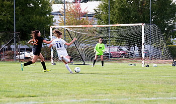 ženy hrají fotbal, fotbal, Ženské atlety, brankář, obhajující cíl, Živá fotbalová hra, venkovní sporty, fotbalové hřiště, soutěž, sportovní akce, týmové sporty