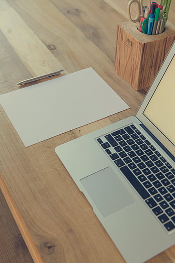 Macbook Pro, Brown Wooden Table, minimalist desk, laptop, papers, stationery, productivity, wooden desk, office setup, workspace, desk organization