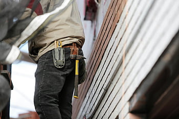 construction worker, black denim pants, hammer, tools, holster, close-up, focused job, tool belt, work attire, construction site, building materials