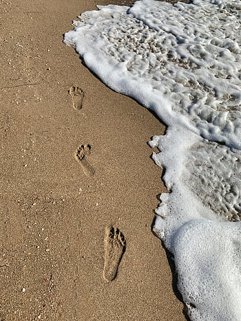 footprints, brown sand, ocean waves, gentle waves, clear sky, beach scene, sandy beach, coastal view, seaside, nature photography, tranquil scene