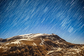 star trails, snow covered mountain, winter night sky, star streaks, mountain landscape, clear night, breathtaking view, snowy mountain, night photography, star photography, winter scenery