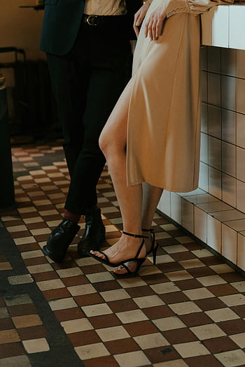 woman in beige dress, black leather shoes, elegant couple, tiled bar counter, stylish appearance, sophisticated look, checkered floor, fashion photo, modern style, chic outfit, formal attire