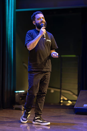 man speaking, audience, microphone, stage, professional presentation, confident speaker, event, public speaking, presentation skills, speaker on stage, formal event