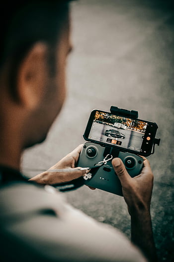 ドローンコントローラー、 スマートフォンモニター、 現代の技術、 クローズアップの人、 ドローンを操作する、 スマートフォン、 ドローン操作、 テクノロジーショーケース、 ハンドヘルドデバイス、 リモコン、 ドローン飛行