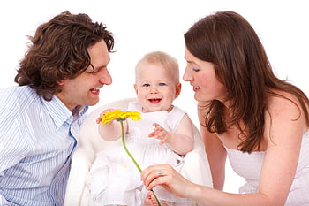 moment de familie, părinții și copilul, Cămașă cu dungi alb și gri, rochie albă fără mâneci, Rochie albă fără bretele, floare galbenă, Familia veselă, Părinții care țin floare, Copil în rochie albă, poza de familie, familie fericita
