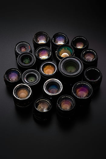 camera lenses, diverse collection, sleek black surface, different kinds, photography equipment, lens variety, optical lenses, camera accessories, lens collection, black background, camera gear