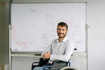 Uomo in sedia a rotelle, uomo sorridente, Presentazione aziendale, grafici, lavagna, presentazione in sedia a rotelle, uomo professionista, altoparlante accessibile, Grafici di presentazione, ambiente di ufficio, 残疾人士生意展示