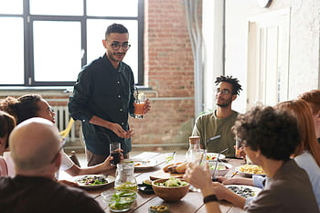 uomo che tiene bevanda, gruppo di amici, Ambiente interno moderno, pasto insieme, promozione della connessione, gioia, tavolo da pranzo, ritrovo sociale, pranzo moderno, pasto casual, pranzo interno