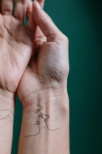 temporary tattoo, delicate tattoo, wrist tattoo, black tattoo, right hand, green background, skin art, close-up, temporary skin art, wrist art, hand tattoo