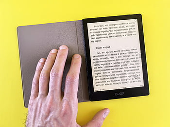 hand holding e-reader, e-reader text display, yellow background, modern digital reading, e-reader device, text on e-reader, bright yellow background, digital reading device, e-reader showcase, hand on e-reader, BOOX e-reader