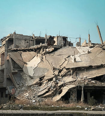 destroyed building, gray concrete, blue sky, urban decay, demolition, rubble, exposed concrete, destruction, abandoned structure, war damage, collapsed building