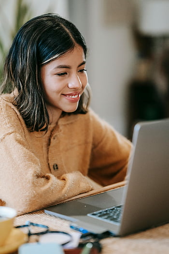 donna sorridente, lavoro a distanza, il computer portatile, lavoro freelance, ufficio a casa, impiegato etnico, giovane donna, lavorare da casa, lavoratore felice, Apazio di lavoro accogliente