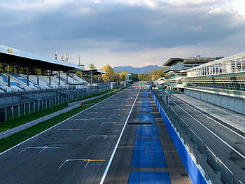Monza-circuit, Italië, lege put rechtdoor, sereen middaglicht, wolken, racebaan, lege tribunes, blauwe barrières, buitensport, motorsport