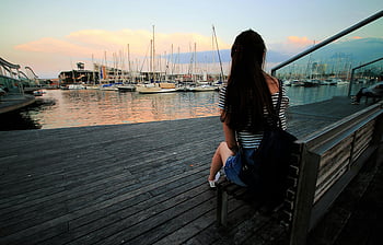 woman, black and white stripe, scoop neck shirt, brown wooden bench, ship dock, marina, sunset, serene, daytime, sitting, bench