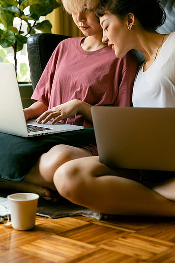 Mujeres que usan computadoras portátiles, sentado en el piso, Estilo de vida moderno, trabajando en casa, dos mujeres, Disfrutando el tiempo juntos, oficina en casa, Trabajo informal, asiento de piso, computadoras portátiles, entorno interior