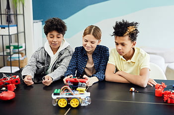 teens, robotics, teamwork, technology skills, indoor activity, remote controlled cars, building robots, group activity, educational project, STEM learning, collaboration