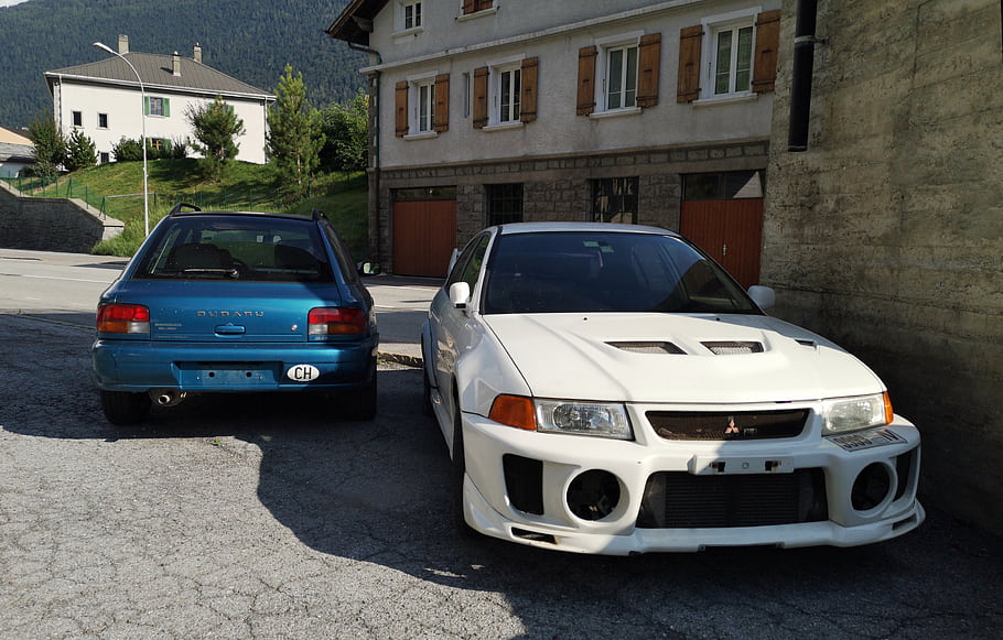 subaru impreza, Mitsubishi Lancer Evo V, vozy, zaparkováno, venku, budova, Okna, modré auto, bílé auto, silnice, stromy