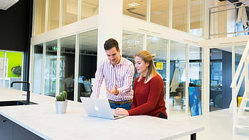 man and woman, laptop computer, modern office, colleagues collaborating, professional setting, workspace, teamwork, business environment, office technology, office interaction, modern workplace