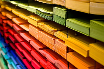 multi colored folders, vibrant paper stacks, stationery store, colorful folders, multicolored paper, arranged shelves, office supplies, bright folders, paper organization, stationery display, rainbow folders