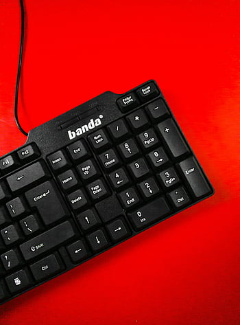 schwarze Computertastatur, rote Oberfläche, Modernes Tech -Design, detaillierte Ansicht, leuchtend rot, Banda-Tastatur, schwarze Tastatur, roter Hintergrund, technisches Produkt, Computerzubehör, Tastaturdesign