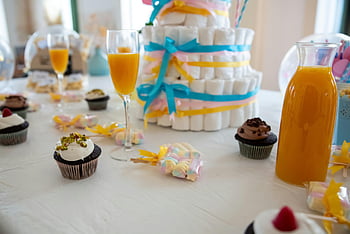 baby shower, cupcakes, white tablecloth, orange juice, diaper cake, ribbon-wrapped, decorated table, party table, marshmallows, baby shower decorations, festive table