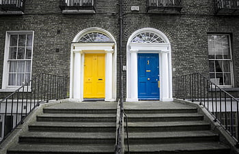yellow door, blue door, historic building, brick facade, steps, doorway, vivid colors, closed doors, architectural details, urban scene, entrance