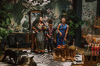 Kwanzaa celebration, women dancing, traditional attire, holiday decorations, indoor celebration, African culture, festive atmosphere, cultural event, group of women, holiday tradition, festive gathering