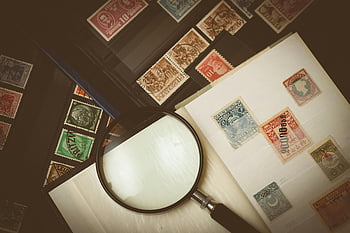sbírka známek, Vintage poštovní známky, Zvětšovací sklo, složité návrhy, Podrobný pohled, Album známek, filatelie, Sběratelské známky, Razítko, Zkoumání známky, Strana alba razítka